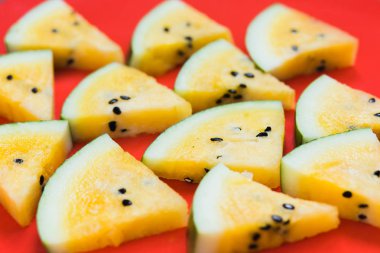 beyaz arka plan üzerinde olgun sarı karpuz üçgen dilimleri kesmek