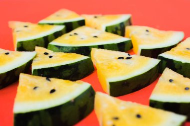 kırmızı arka plan üzerinde olgun sarı karpuz üçgen parçaları bir sürü