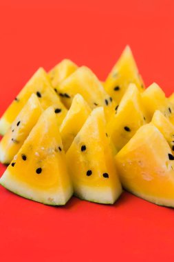 kırmızı arka plan üzerinde olgun sarı karpuz üçgen parçaları bir sürü