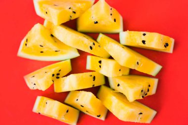 kırmızı arka plan üzerinde olgun sarı karpuz üçgen parçaları bir sürü