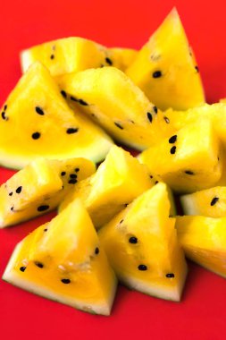 kırmızı arka plan üzerinde olgun sarı karpuz üçgen parçaları bir sürü