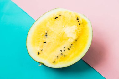 mavi-pembe arka plan üzerinde olgun sarı karpuz üçgen dilimleri kesti