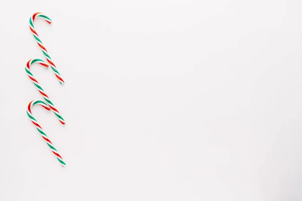 Traditional christmas sweets, candy cane sweets on white background, simple pattern, layout, on white background, top view.minimal concept