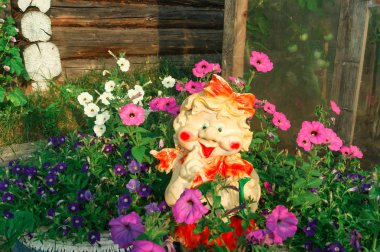 Rengarenk Petunyalar ve neşeli bir bahçe heykeli.