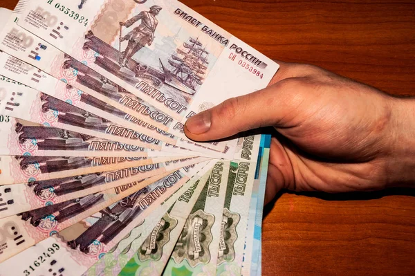 Ryska sedlar som en fläkt i händerna — Stockfoto