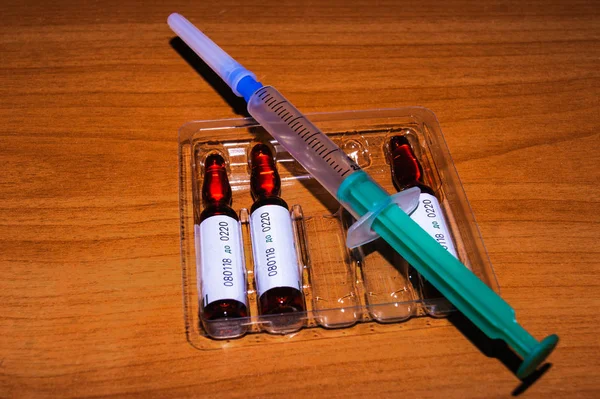 Medizinische Spritze mit Ampullen auf einem Tisch in Großaufnahme — Stockfoto