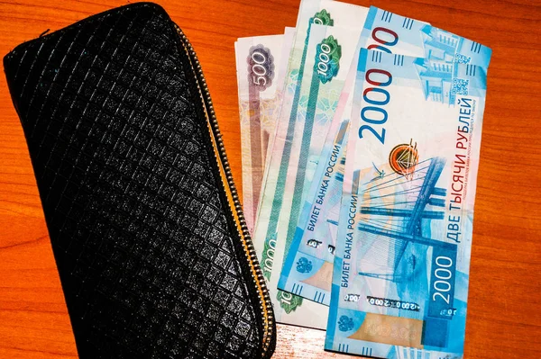 Ryska sedlar och svart plånbok på bordet. — Stockfoto