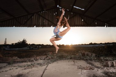 Genç kız dışarıda ritmik jimnastik yapıyor.