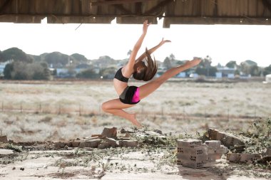 Genç kız dışarıda ritmik jimnastik yapıyor.