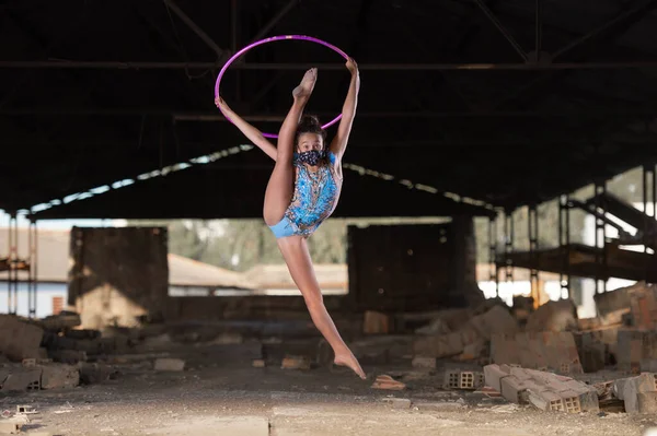 Genç kız dışarıda ritmik jimnastik yapıyor.