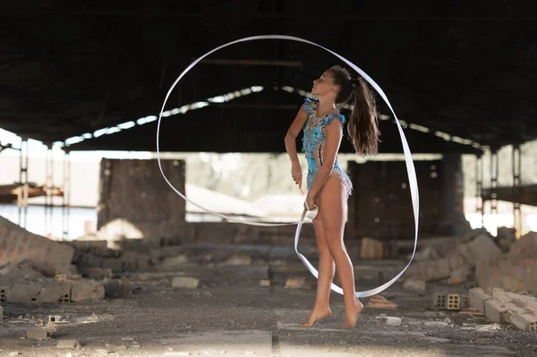 Genç kız dışarıda ritmik jimnastik yapıyor.