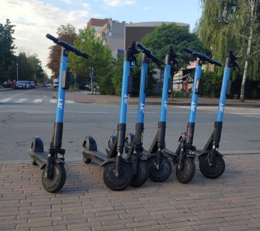 Electric scooters parked on the sidewalk of a city street. City transport. Electric scooter rental.