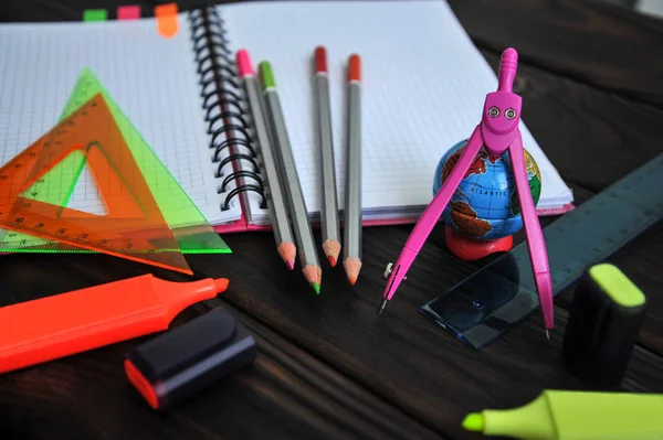 üstünde bir koyu ahşap masa, üstten görünüm yalan bir defter Kırtasiye bir küre ve işaretleri ile dağılın