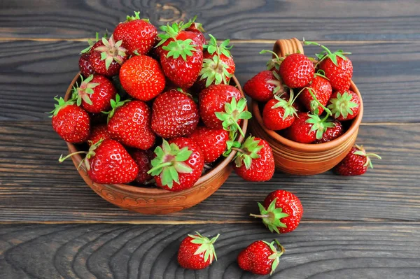 Las fresas en la cerámica sobre la mesa de madera. Vista desde arriba —  Fotos de Stock