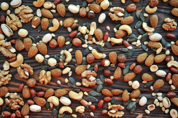 Ahşap bir yüzey üzerinde çeşitli fındıkların arka planı