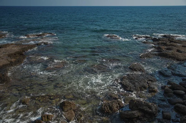 Güzel deniz, kıyıya yakın büyük taşlar ve turkuaz su.