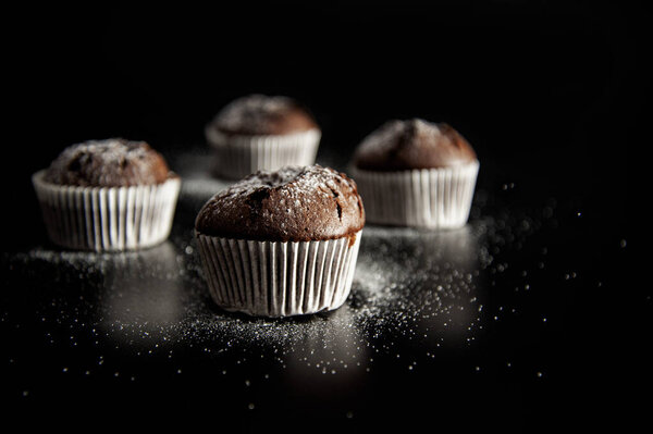десерт из кексов на черном фоне с сахарным порошком