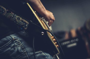 Bir adam ahşap elektro gitar çalmak