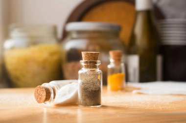 Bir mutfak masasında tuz ve biber ile iki cam kavanoz, bir kara zeminde Curcuma ile kavanoz