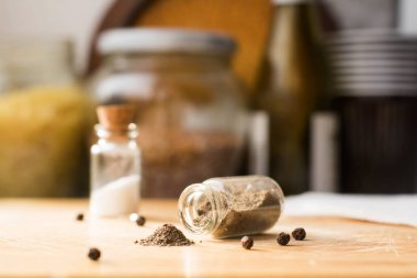 Bir mutfak masasında biber küçük yığını, karabiber ile cam düşmüş kavanoz