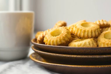 Sarı kurabiye ve beyaz kupa ile plaka