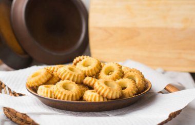 Beyaz peçete üzerinde yuvarlak sarı kurabiye ile plaka