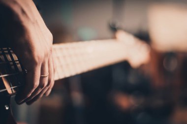 Bir müzisyen bir stüdyoda bas-gitar oynuyor