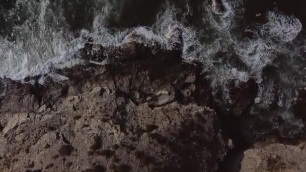 Mer avec des vagues s'écrasant sur les rochers et la route par la mer