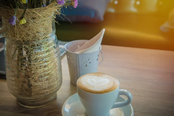 ラテアートコーヒーやカプチーノを木のテーブルの上に背景に — ストック写真