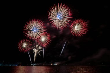 Geceleyin çeşitli renklerde renkli havai fişekler ve kutlama ve yıldönümü konsepti..