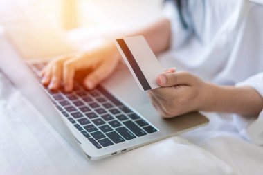 Bir laptop ve kullandığı kredi kartı üzerinde iş çalışma ve konsept alışveriş genç kadın.