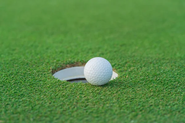 Bola de golfe no lábio da xícara no golfcourt — Fotografia de Stock