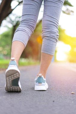 Atlet koşucu ayakları kadın su yol boyunca yeşil parkta çalışan