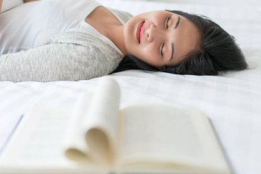 Güzel kadın bir boo okuduktan sonra uyku yatakta uyku