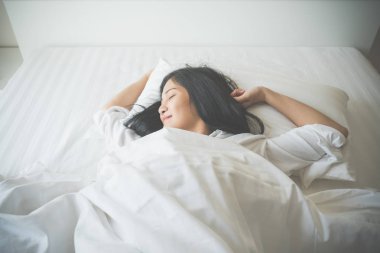 Yatak odası, yatakta uyuyan güzel genç kadın