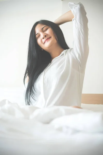 Gyönyörű fiatal nő felébredni, és nyúlik magát, reggel — Stock Fotó