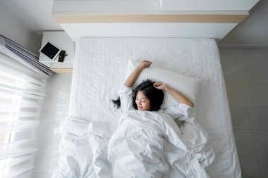 Yatak odası, yatakta uyuyan güzel genç kadın
