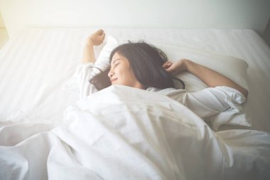 Yatak odası, yatakta uyuyan güzel genç kadın