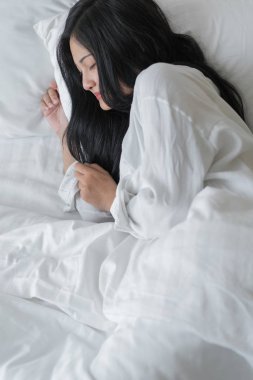 Yatak odası, yatakta uyuyan güzel genç kadın