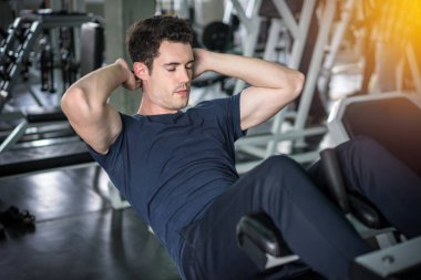 Yakışıklı adam spor salonunda karın egzersiz kadar oturup yapıyor egzersiz