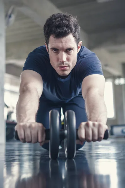 Athlète homme sportif faisant de l'exercice avec roue à rouleaux abs à stren — Photo