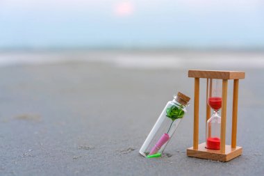 Tropik plajda kum saati ile şişeiçinde mesaj veya mektup