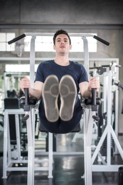 Yakışıklı adam fitnes makine oluşturucu kasları kol egzersiz