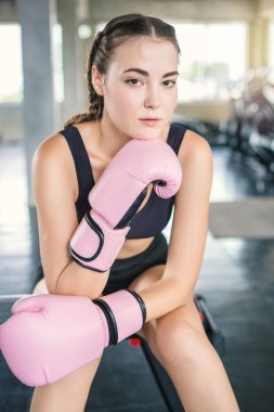 Spor salonunda boks eldivenli genç ve güzel bir kadın.