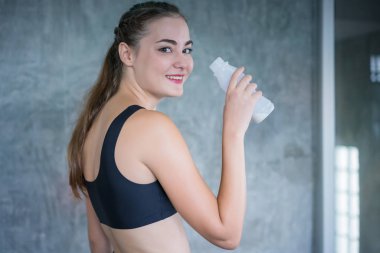 Genç kadın egzersiz exer sonra şişeden süt proteini içme