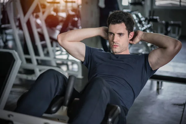 Hombre guapo haciendo ejercicio sentado ejercicio abdominal en el gimnasio — Foto de Stock