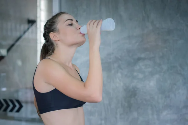 Mujer joven bebiendo proteína de leche de botella después del ejercicio exer — Foto de Stock