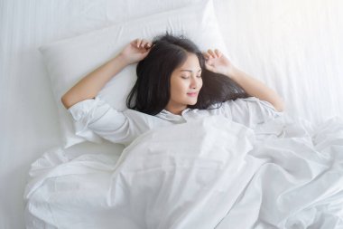 Yatak odası, yatakta uyuyan güzel genç kadın