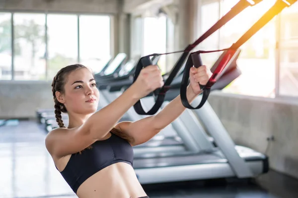 Atleta desportiva mulher fazendo exercício com fitness trx tiras para s — Fotografia de Stock