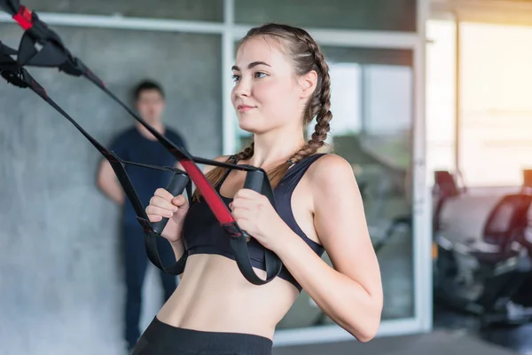 Atleta desportiva mulher fazendo exercício com fitness trx tiras para s — Fotografia de Stock